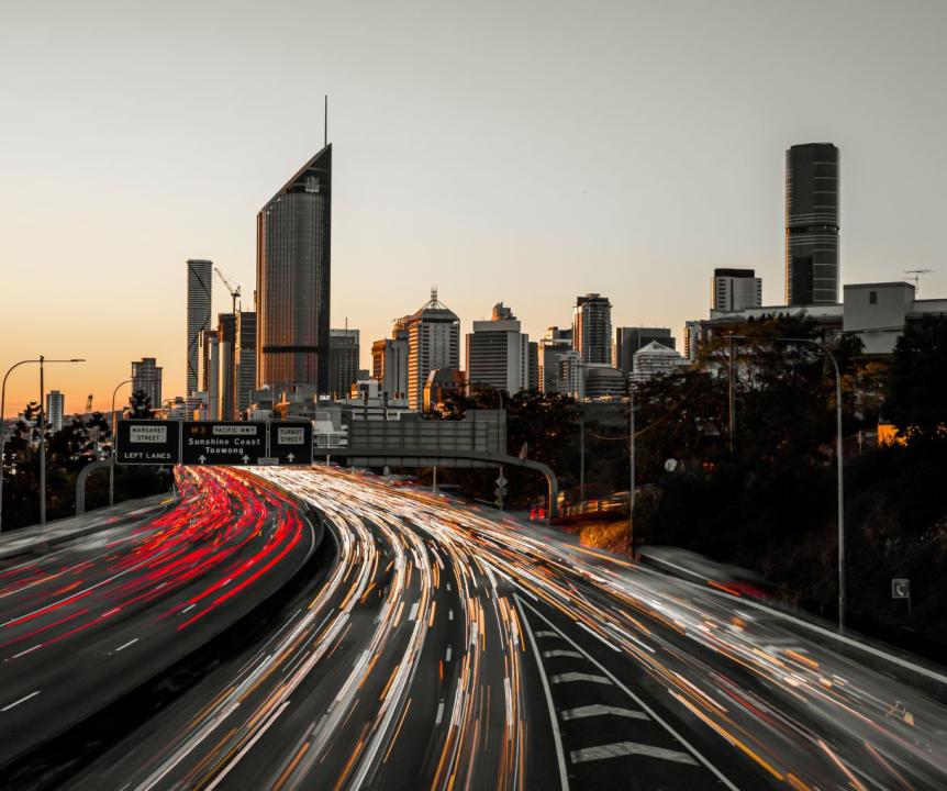 Traffic moving past Brisbane city at sunset